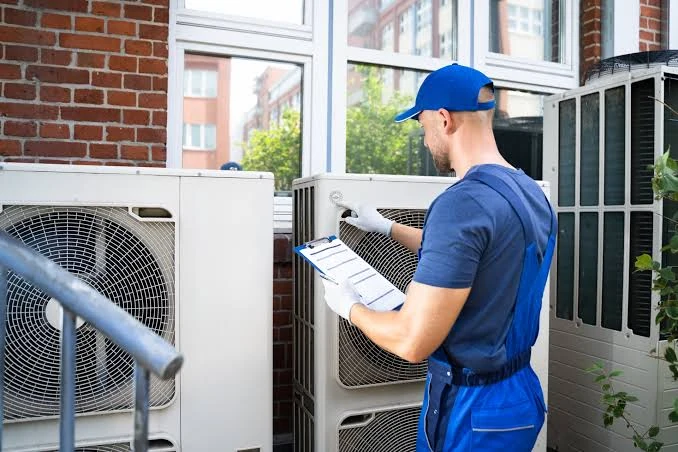 Technician with a checklist inspecting outdoor air conditioning equipment