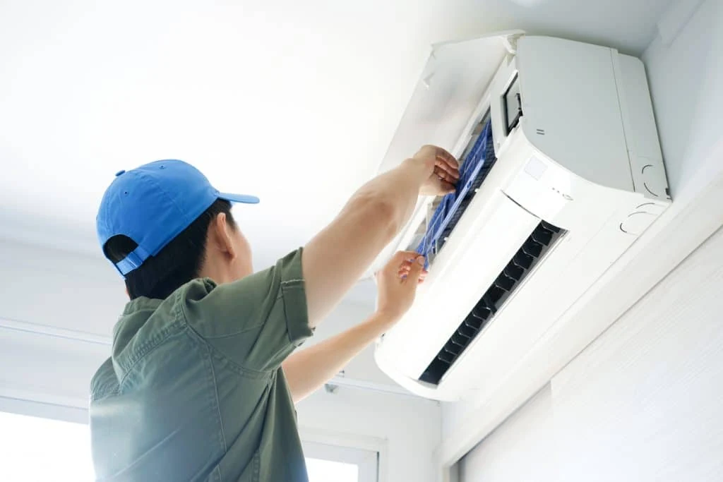 Technician maintaining the filter of a wall-mounted indoor air conditioner